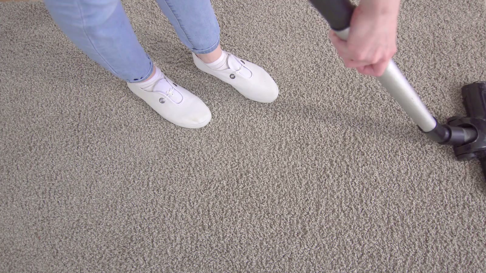 Vacuuming wall-to-wall carpet before a deep clean, the first step of carpet cleaning in a Los Angeles home