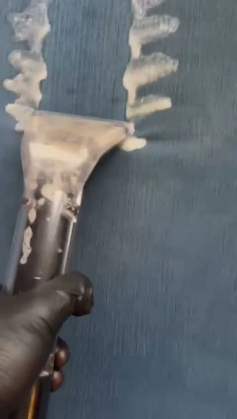 Good Day Cleaners technician rinsing and extracting fabric with a handheld upholstery tool during an in-home cleaning in Los Angeles