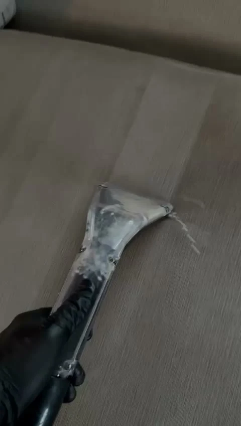 Good Day Cleaners technician extracting water and soil from a fabric sofa during an in-home cleaning in Los Angeles